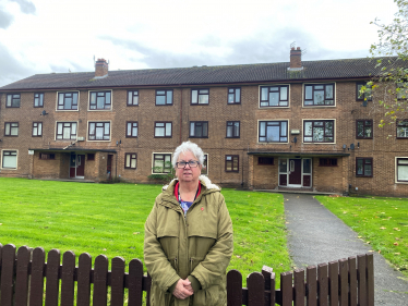 Cllr. Vida Wilson in front of the three blocks in Berrylands Rpad